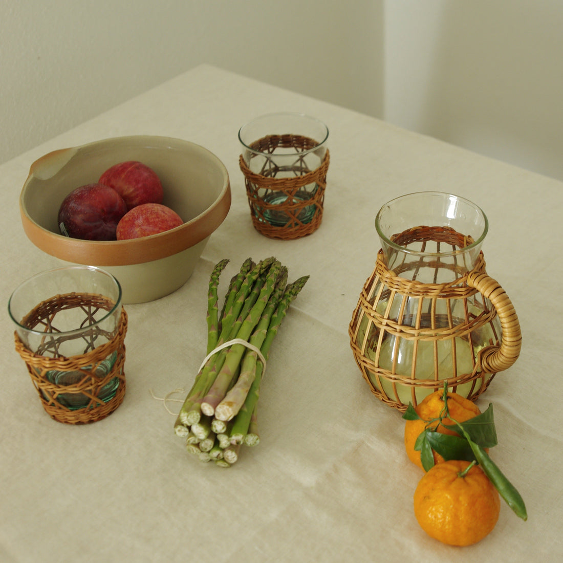 Be Home Seagrass rattan wide cage tumbler in hand-woven rattan over glass, styled in a room setting